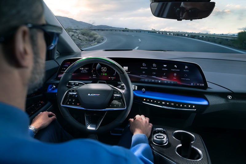 Front View of the 2026 OPTIQ-V Driving Through the Dusk Utilizing its Headlights | Bergstrom Cadillac of Green Bay in Green Bay WI